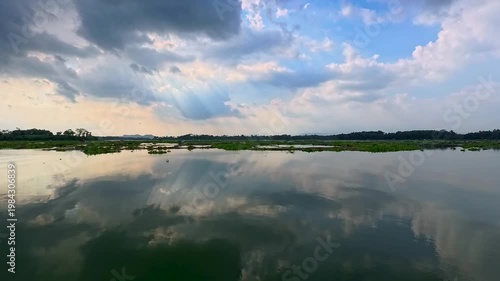 Aerial view of Sutami Dam at sunset with golden reflections on the reservoir water