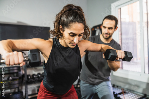 Tableau sur toile Woman performing functional training with personal trainer