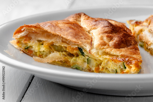 Tortino di pasta sfoglia ripieno di uovo, zucchine, carote e cipolla, spuntino vegetariano 