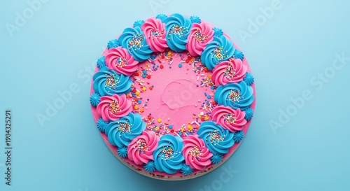A vibrant circular cake with bright pink and turquoise frosting swirls around the edges and colorful sprinkles in the center, set against a soft blue background.