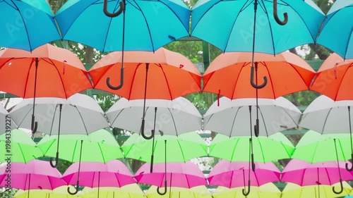 Walking under canopy of umbrellas in a park. Garden decor
