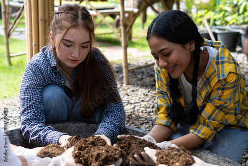 A young woman is preparing the soil for planting.