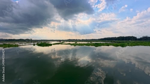 Aerial view of Sutami Dam at sunset with golden reflections on the reservoir water