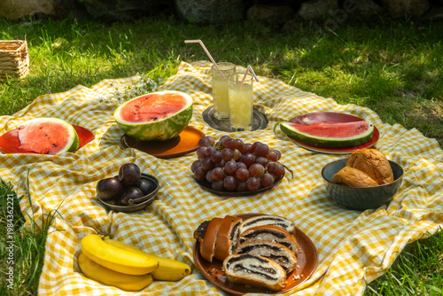 Summer vibes. Picnic food on checkered yellow and white blanket.