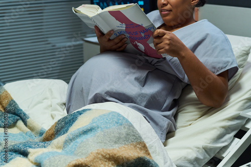 Εκτύπωση καμβά Midsection of pregnant woman reading pregnancy guide while resting in hospital bed, preparing for childbirth and prenatal care
