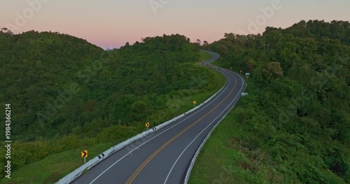Aerial drone view of a picturesque mountain road shaped like the number three in Nan Province. This famous viewpoint attracts travelers and photographers seeking breathtaking curves and stunning