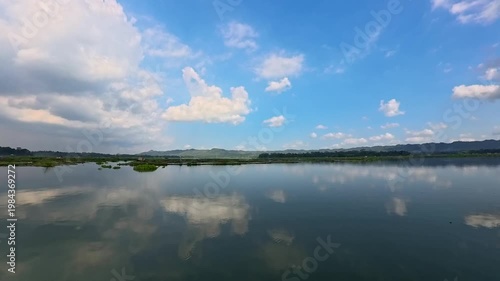 Aerial view of Sutami Dam at sunset with golden reflections on the reservoir water