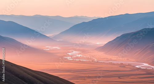 A serene mountain landscape with a river flowing through a valley at sunset