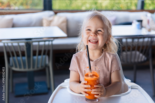 Girl toddler drinking carrot juice