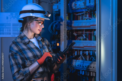 Technical specialist working with tablet near electrical panel. Engineering inspection.