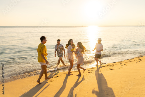 Obraz na plátně Group of diverse friends having fun playing together on beach at sunset enjoy su