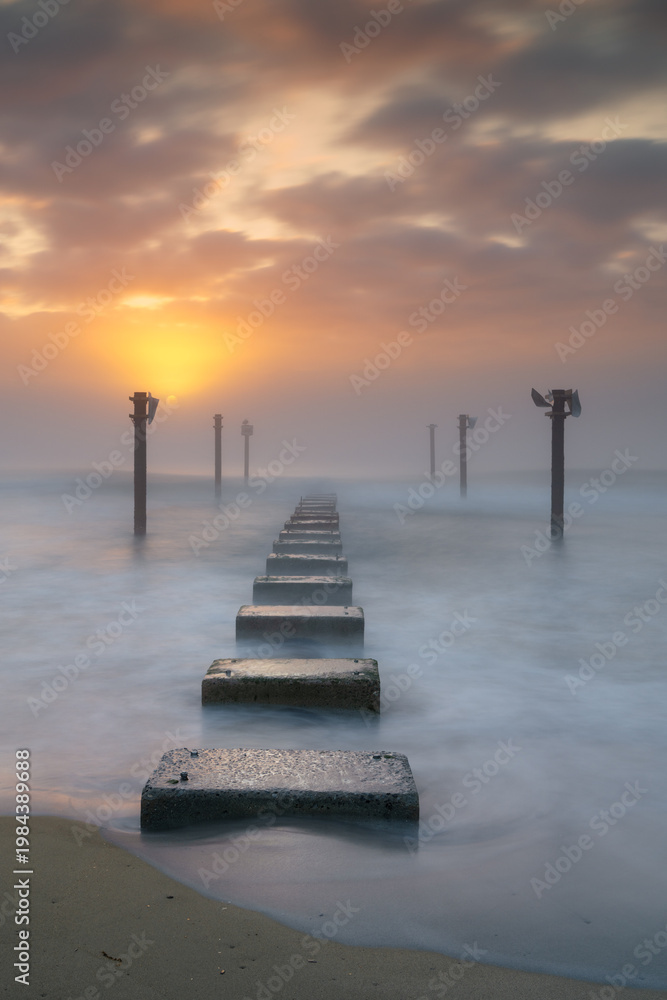 Fototapeta premium view of the remnants of a wooden pier at Carolina Beach in Wilmington t sunrise