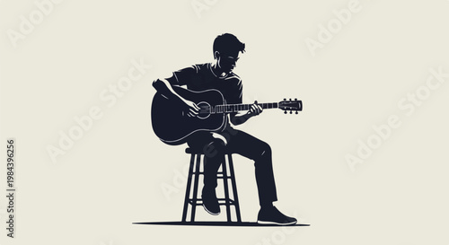 Silhouette of a young man playing an acoustic guitar while sitting
