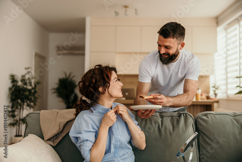 Schilderij op canvas Husband bringing breakfast in bed to smiling wife