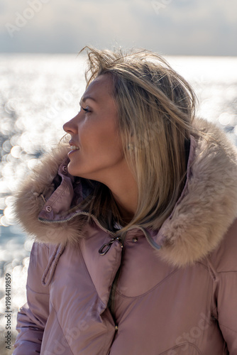 Fényképezés Woman Coastline Winter Jacket: Outdoor portrait, blonde woman seaside, cold weather, contemplative mood