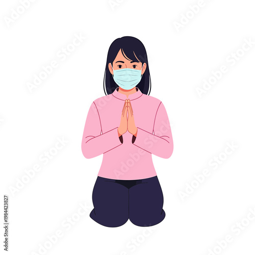 Woman wearing face mask kneeling with hands in prayer position