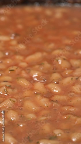 Cooking beans in tomato sauce. Canned beans. The process of cooking beans, stirring, and adding spices.	
