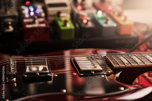 electric red sg guitar and pedalboard on a carpet. pedal effects fx background. Selective focus