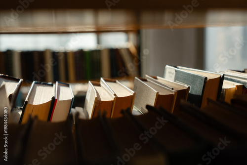 Vászonkép Old books on the bookshelf in library archive interior in sunny day