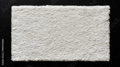 Fluffy white rectangular rug on black background, dense fur, neat edges, natural texture, soft and cozy.