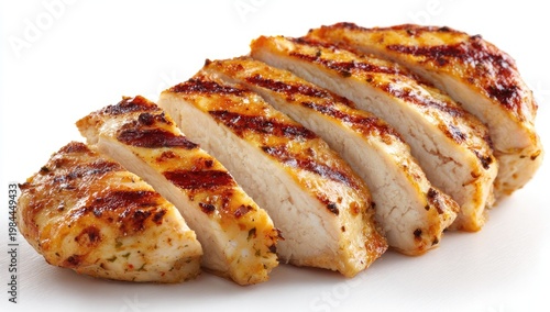 Sliced grilled chicken breast with char marks and seasoning on white background
