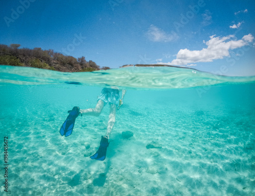 Tableau sur toile Split View of Snorkeler in Turquoise Caribbean Water Beneath Blue Sky
