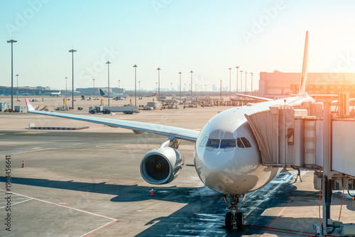Cuadro en lienzo A gleaming wide-body aircraft connects to a passenger boarding bridge on a vibrant tarmac