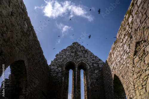 Irish Stone Church Exterior with Birds Flying in Blue Sky Historic Architecture