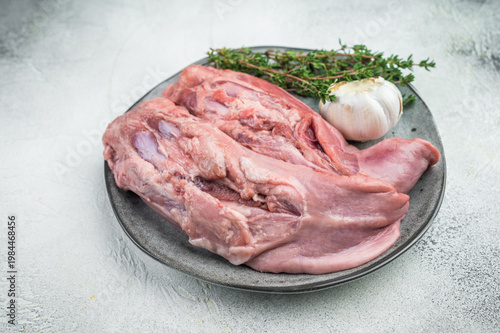 Canvas Print Raw lamb tongues on ceramic plate with thyme and garlic isolated on white backgr