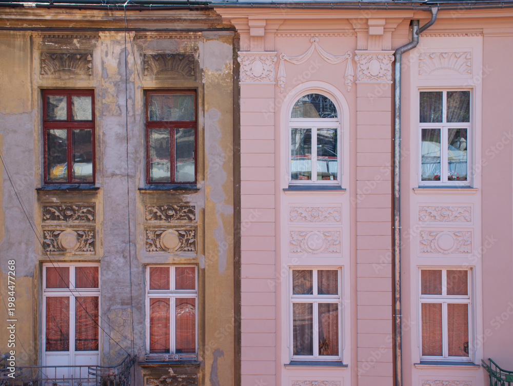 Fototapeta premium Side by side contrast of old weathered and newly renovated building facades in city. Architectural comparison showing decay, restoration, and urban renewal concept. Detailed exterior with windows.