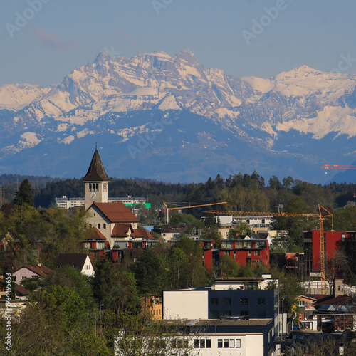 Church of Wetzikon and snow capped mountains, Zurich Canton, Switzerland..