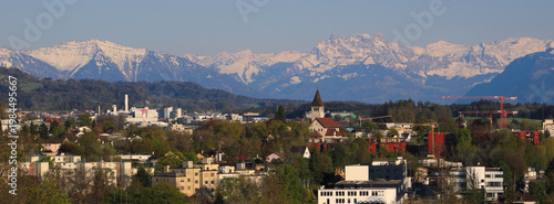 Wetzikon and snow covered mountain range, spring day in Zurich Canton, Switzerland.