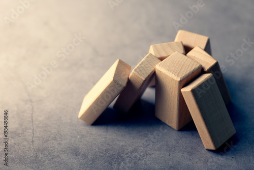 Multiple wood blocks rely on a single support, representing overdependence, key person risk, and vulnerability in business structure or operations