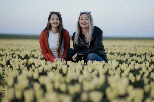 two beautiful Women standing in colorful tulip flower fields in Amsterdam region, Holland, Netherlands. Magical Netherlands landscape with tulip field in Holland Trevel and spring concept