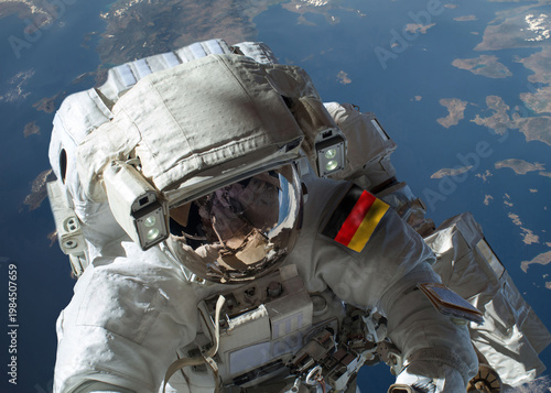 Close up view of German astronaut in outer space during a spacewalk with planet Earth in the background. Elements of this image furnished by NASA and ESA.