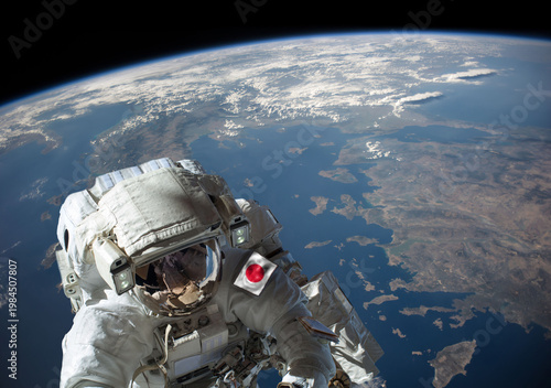 Japanese astronaut in outer space during a spacewalk with planet Earth in the background. Elements of this image furnished by NASA.