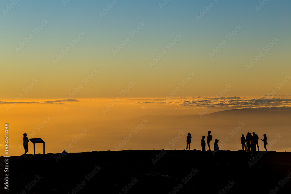 Naklejka premium Silhouettes of visitors watching sunset at Haleakala Maui Hawaii