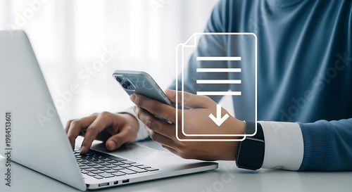 Man using a laptop and smartphone for digital document management and data transfer