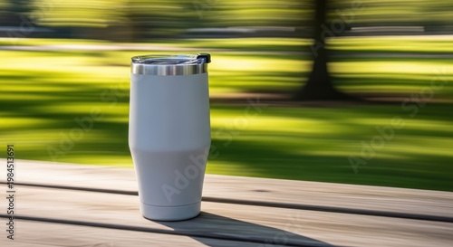 White insulated tumbler on a wooden table.