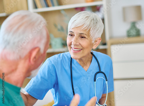 Portrait of a senior doctor or nurse caregiver talking consultation with senior man at home or nursing home