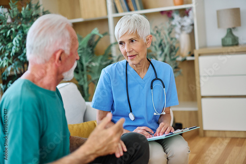 Portrait of a senior doctor or nurse caregiver talking consultation with senior man at home or nursing home