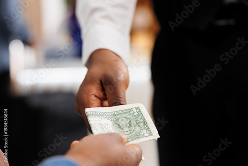 Fotografía Close up of hospitality worker accepting of cash payment, taking money from customer