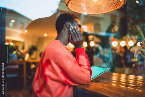 Pensive young woman looking away with inspiration while working on her digital tablet in a stylish cafe setting, symbolizing career growth, digital freedom and mindful remote work lifestyle.
