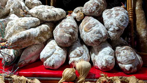 Traditional cured sausages with rustic texture and natural casing displayed in market setting. Food production concept for meat industry branding culinary tradition and artisanal product visuals