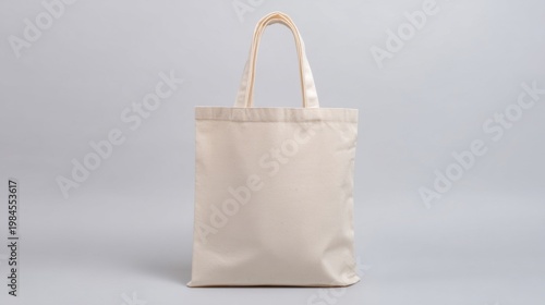 A beige canvas tote bag with plain front and short handles, placed on light gray background, simple and elegant, customi