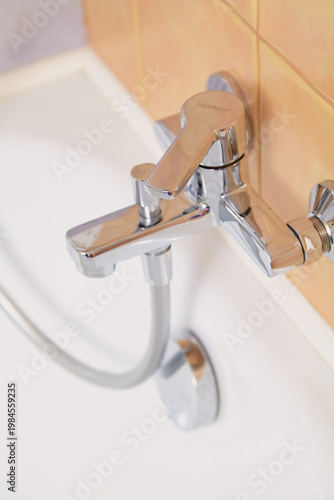 Steel mixer close-up on  modern bathtub