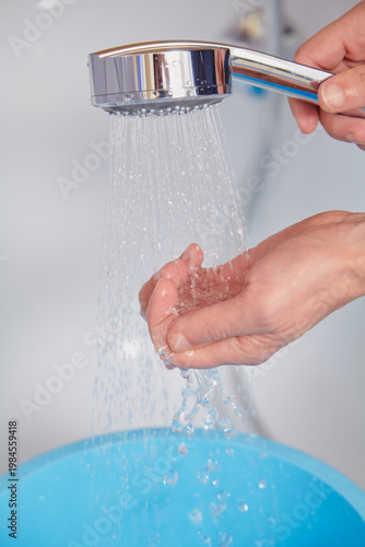 Hand holding modern shower head