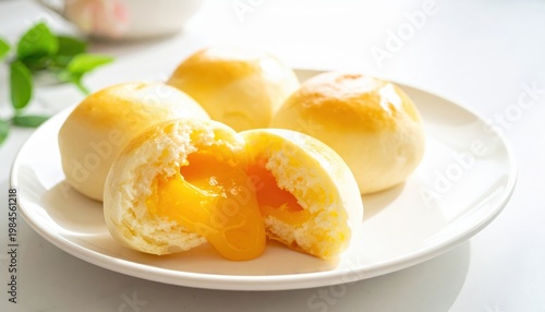 Fluffy steamed custard buns with a sweet molten golden filling oozing out, a delightful dessert treat.
