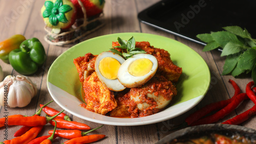 Fényképezés Bali telur, a classic Indonesian side dish of hard-boiled eggs and tofu in a rich spicy sauce, is often enjoyed with steamed white rice