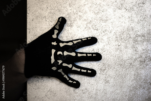 Single Skeleton Glove Hand On Textured Light Surface